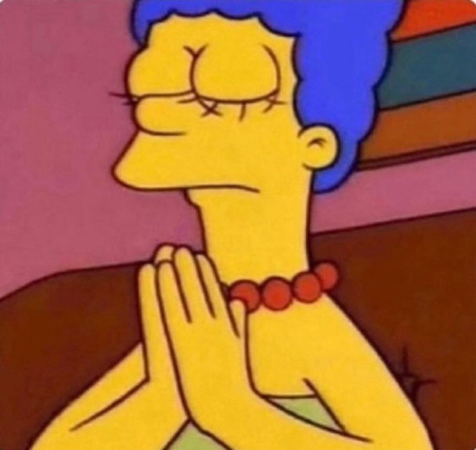 A still from The Simpsons showing Marge with her eyes closed and hands clasped in a prayer position.
