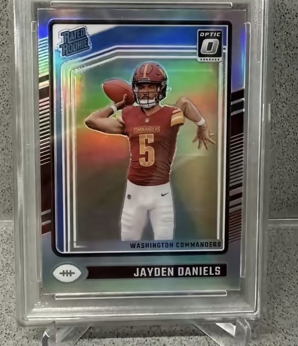 A graded 'Rated Rookie' Optic Donruss football card featuring Jayden Daniels of the Washington Commanders in a protective case.