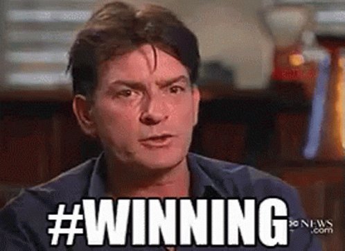 The image features a man with short hair wearing a blue shirt, sitting at a table or desk. He has a serious expression on his face as he looks directly into the camera. The background of the image includes a chair and a cup, suggesting that this might be an office setting. There is also text in the image that reads "Winning" with a hash symbol (#) above it.