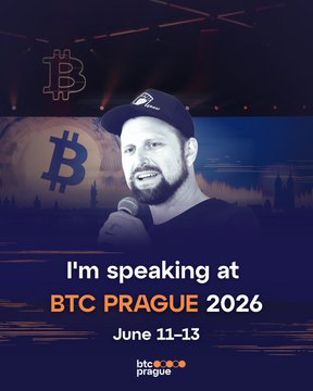 The image features a man wearing a baseball cap, speaking into a microphone at a stage. The background of the image shows a city skyline with a clock indicating that it's 11:13 am. The caption below the image reads "I'm speaking at BTC Prague 2026".