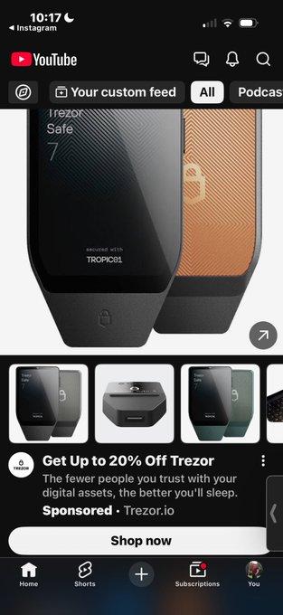 A sponsored YouTube ad for a Trezor hardware wallet appears, promoting "Up to 20% Off Trezor" with the tagline "The fewer people you trust with your digital assets, the better you'll sleep," which highlights the irony given the poster's criticism of Coldcard's security failures and missed opportunity to dominate the hardware wallet market.