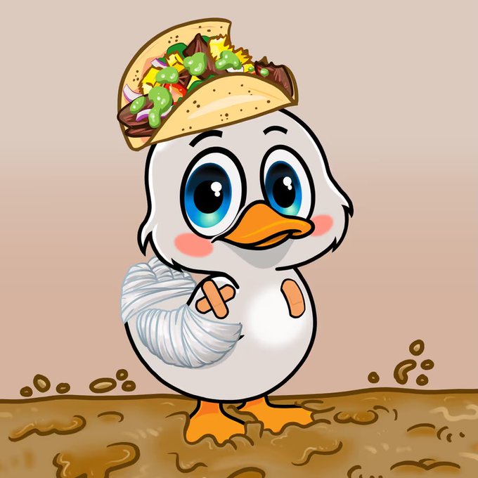 A cute cartoon duck with a bandaged wing and rosy cheeks is balancing an oversized taco on its head, standing on a dirt ground. The image pairs perfectly with the post's playful theme, illustrating the "Taco Tuesday" YD Trait collection, with the duck's taco-adorned head and wrap mimicking the fun, Friday-celebrating spirit of the limited-edition NFT.