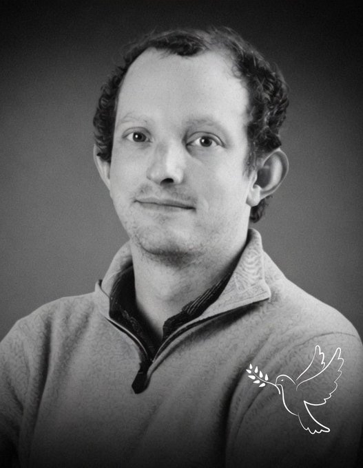 The image features a man with curly hair wearing a gray sweater, looking directly at the camera. The background of the photo is black and white, which gives it an artistic touch. There are two birds depicted in the image - one on top of the other, symbolizing peace or unity. The text "Really gutted by this news. Ondo Finance just announced that their founder and CEO, Nathan Allman, has passed away at just 32. He was one of the people actually making tokenized real-world assets work bridging traditional finance and crypto in a meaningful way." is present within the image.