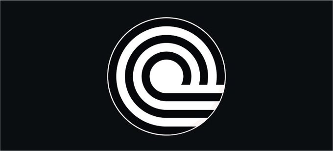 A stylized circular logo featuring concentric white and black rings with a central white dot, set against a dark background, representing Ondo Finance's branding as the company expands its 24/7 tokenized stock trading offerings to include AMZNon, MSTRon, COINon, ORCLon, and TQQQon.