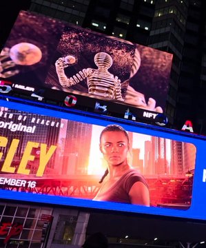 A nighttime city view shows large illuminated billboards, including advertisements for "RPLEY" and NFT, featuring a muscular figure and a woman in a red top.