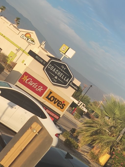A tilted photo shows the Coachella welcome sign surrounded by sponsor logos including Del Taco, Carl's Jr., and Loves, with mountains in the background.