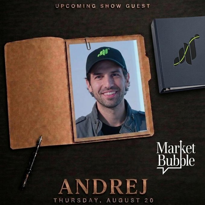 A promotional graphic for "Market Bubble" featuring an upcoming show guest announcement. The image shows a smiling man in a green cap displayed within an open leather folder on a dark wooden desk, with text reading "UPCOMING SHOW GUEST," "ANDREJ," and "THURSDAY, AUGUST 20," teasing Andrej's appearance as the founder of Grass Protocol on the show.