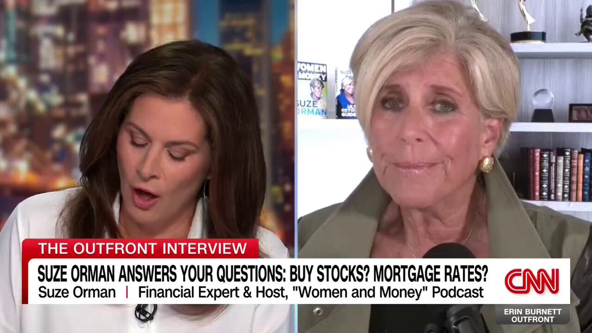 The image shows a conversation between two women, one of whom is a financial expert named Suze Orman. They are discussing whether to invest in gold or bitcoin as an investment option. The woman on the left side of the image has brown hair and is wearing a white blouse, while the other woman with blonde hair is dressed in a green jacket. Both women appear to be engaged in the conversation, possibly sharing their opinions and insights about these two different types of investments.
