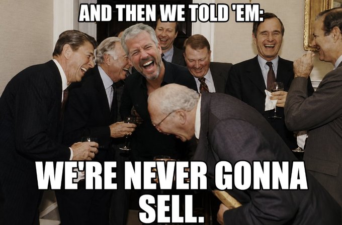 The image shows a group of men dressed in suits, laughing together at each other's jokes. They are all smiling and enjoying themselves. The caption for this image reads "And then we told 'em; We're never gonna sell." This phrase is likely a reference to Saylor and Michael MSTR's partnership or collaboration with another company.