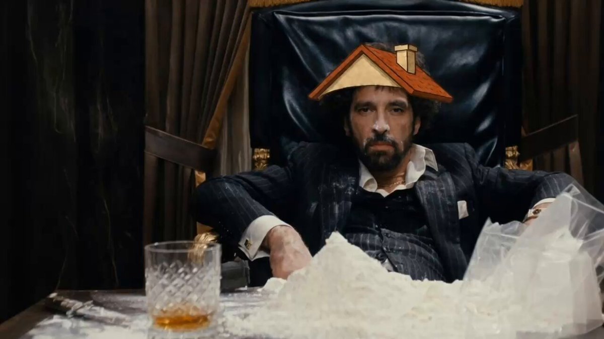 The image features a man sitting at a table with a glass of whiskey, wearing a suit hat that has a house on top of his head. The man appears to be in a relaxed position, possibly enjoying a drink or engaging in conversation. In the background, there is another person who seems to be watching the scene unfold. The image also includes text that reads "say hello to my lil chiller!!!". This suggests that the man might have been referred to as a character from a movie or TV show, and his hat with a house on it could be related to the title of the post.