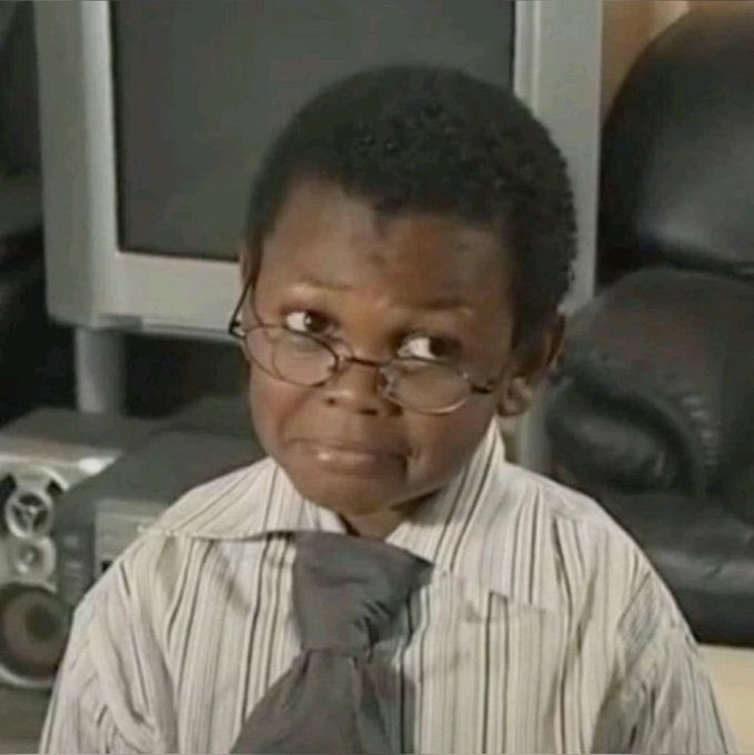 A young boy wearing glasses, a striped shirt, and tie makes a skeptical side-eye expression in what appears to be an office setting with a computer monitor and leather chair in the background. The image humorously illustrates doubt about the claim that a degree isn't necessary to succeed in cryptocurrency, as the boy's doubtful look suggests skepticism toward the notion that anyone can profit from Bitcoin without proper education.