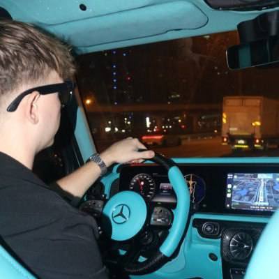 A man drives a turquoise Mercedes-Benz with a custom neon-lit interior and digital dashboard at night, with the steering wheel bearing the recognizable Mercedes logo, projecting a "cruise into the future" vibe that aligns with the post's call to invest early in a Solana token airdrop.