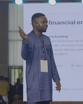 A man wearing a headset and a blue striped shirt stands on stage presenting, with a slide behind him partially reading "financial en..." and "...re building." The image captures the moment described in the post—a speaker at the Solana Summit Nigeria in Uyo discussing Daya's developer-friendly APIs for stablecoin payments and the upcoming Daya Pro platform.