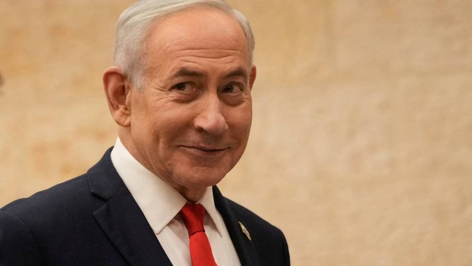 An older man with gray hair, wearing a dark suit, white shirt, and red tie, smiles while standing against a beige stone wall. The image appears unrelated to the post about crypto trading and "Kimchi" — there is no visible text or connection to the financial content described.