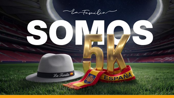 A promotional graphic reading 'La Familia SOMOS 5K' with a grey fedora hat and a Spanish flag scarf displayed on a soccer stadium background.