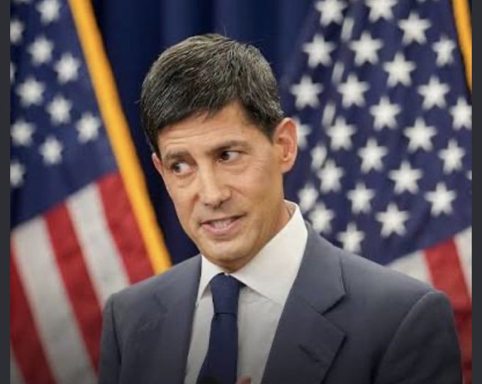 Kevin Warsh, former Federal Reserve Governor, speaks at a press conference with American flags behind him, commenting on the Fed's decision to raise interest rates. His serious expression and formal setting underscore the gravity of the monetary policy announcement, reinforcing the post's emphasis on the "responsible decision" framing.