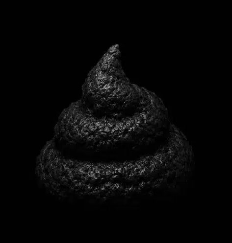 Dark, textured black spiral shape resembling a pile or coil photographed against a completely black background.