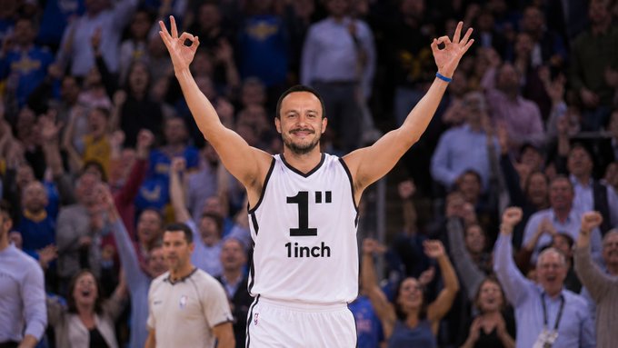 A basketball player in a white "1" 1inch jersey celebrates with arms raised in an arena filled with cheering fans, visually aligning with the post's enthusiastic "Three chains in 2 days. LFG" message about achievements.