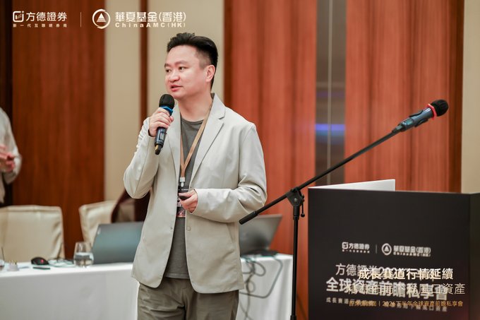 A man in a beige blazer speaks into a microphone at a podium for an event co-hosted by 方德證券 and CHINA AMC (HK), with signage referencing Channel Islands private wealth assets.