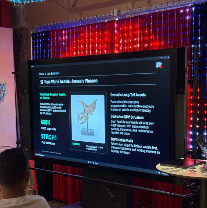 A presentation displayed on a screen about 'Solana Use: Examples' featuring 'Real-World Assets: Jurassic Finance,' showing a triceratops skull tokenized on Solana with a $660K target raise and $TRCH1 token.