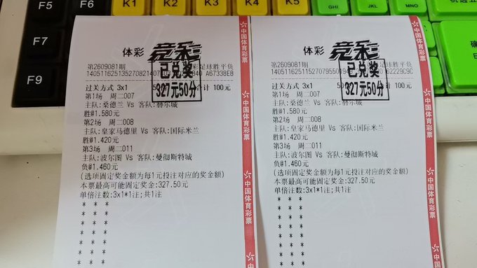 Two identical Chinese sports lottery tickets (体彩竞彩) placed on a keyboard, each marked 完赛 (finished) for 327元50分, showing multiple betting selections with odds and match details.