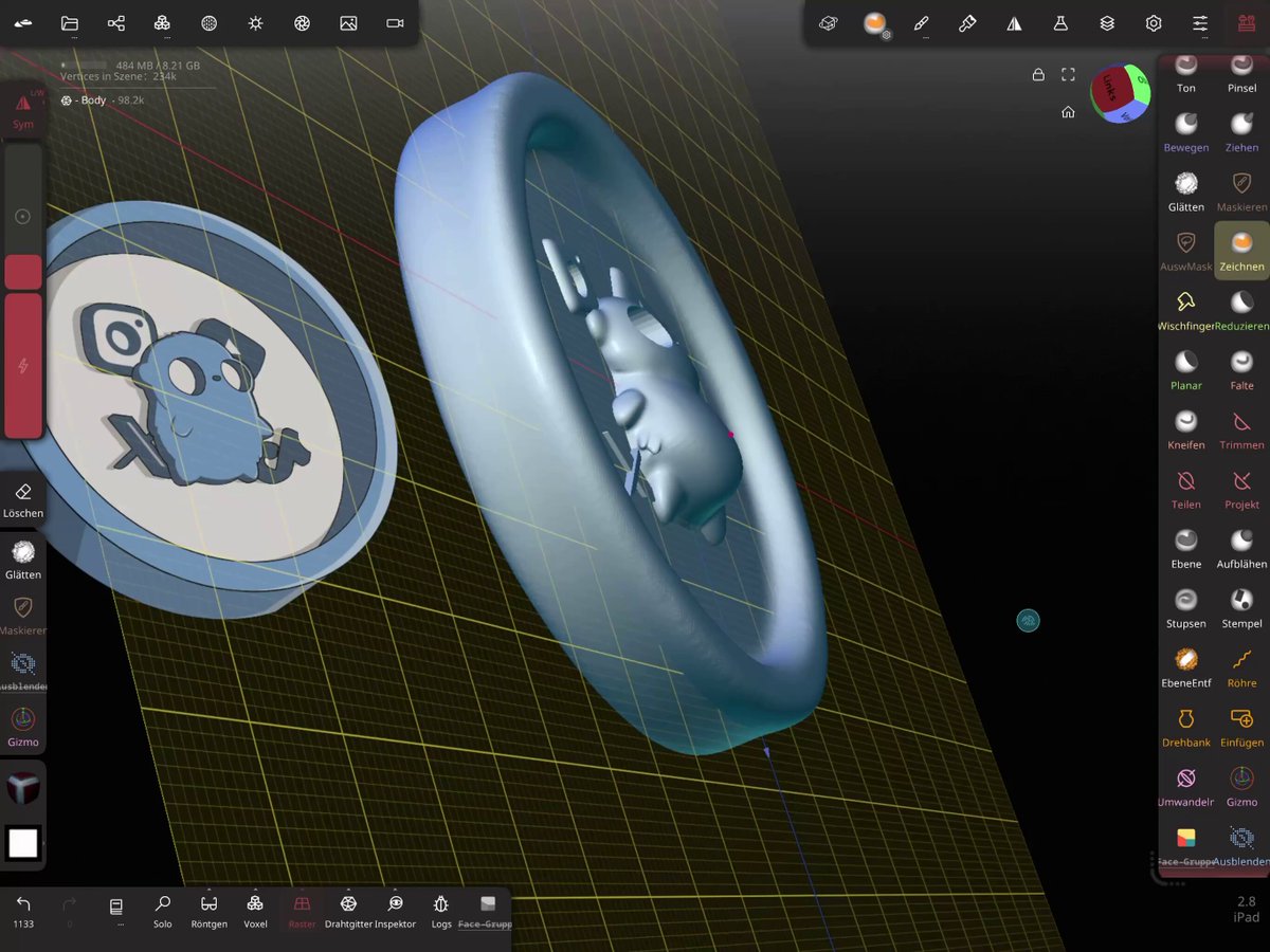 The image shows two 3D printed objects, a blue circle with a white face and a silver ring with a white face, both placed on a grid of yellow lines against a black background. The objects are designed as business cards or keychains that can be used for networking purposes at an upcoming meet-up in Manchester.