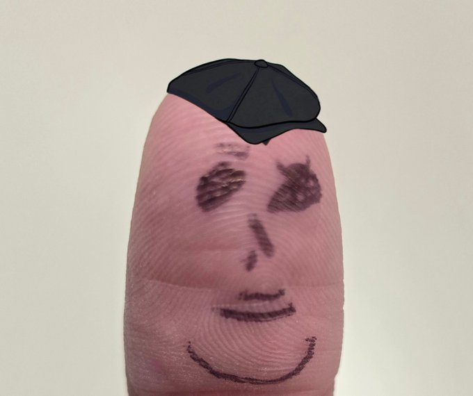 A fingerprint has been turned into a smiling face with eyes and a drawn-on mouth, topped with a digitally added black flat cap hat. The whimsical fingertip portrait fits the HederaPunks.com $HBAR branding by giving a fingerprint-based pun its own "punk" character.