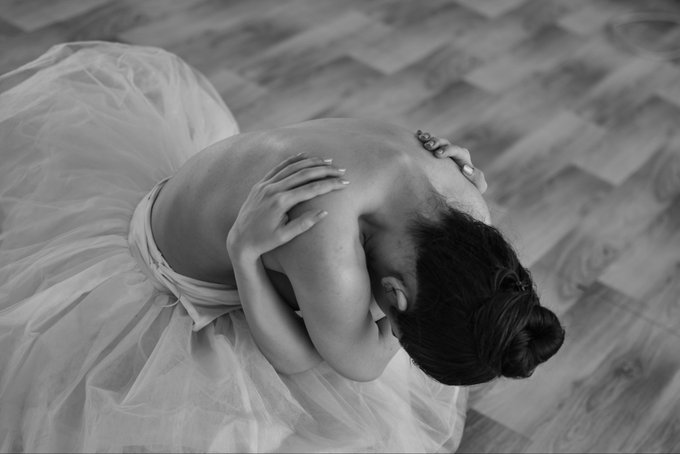 No text is visible in the image. 

The black-and-white photo shows a ballerina curled in a graceful pose on a wooden floor, wearing a flowing tutu that complements the elegant, dance-like quality of the Tezos post.