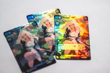 Three trading cards featuring an anime-style character named 'Mizuki' displayed on a gray background, with visible stats and game ability text.