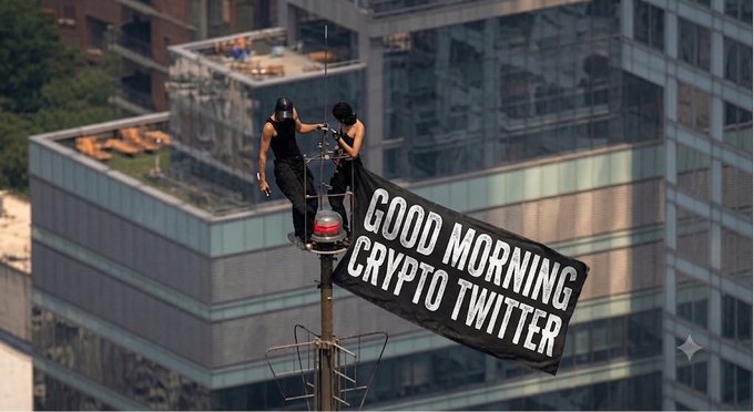 Two people in hard hats standing on a tower crane platform with a banner reading 'GOOD MORNING CRYPTO TWITTER' against an urban skyline.
