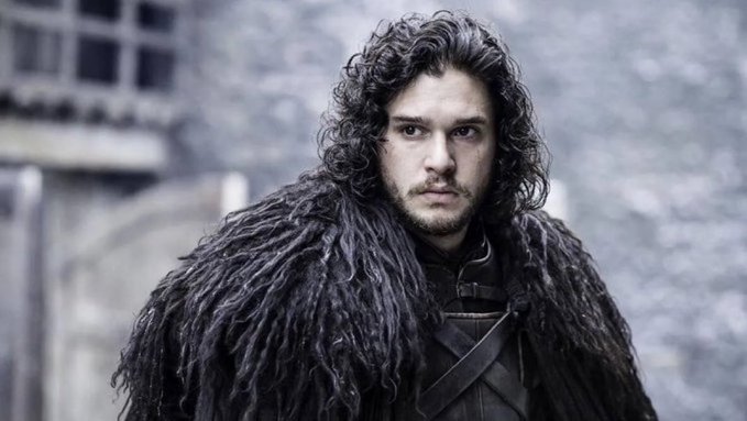 The image shows Kit Harington as Jon Snow from "Game of Thrones," wearing a dark fur cloak with a serious expression. The caption "Uptober is coming" draws a playful parallel to the iconic "Winter is coming" Stark house motto, suggesting an imminent bullish rally in the markets.