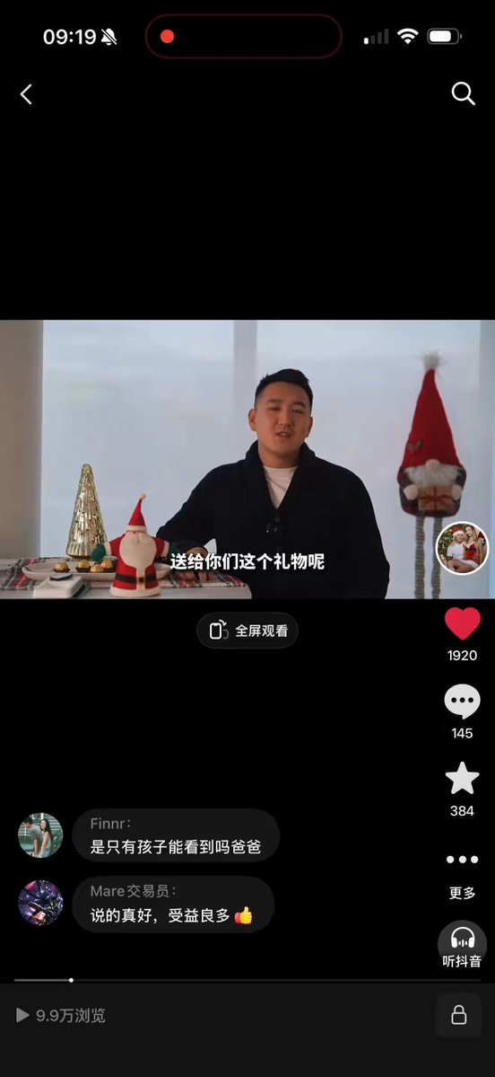 The image shows a man sitting at a table with Christmas decorations, including a Santa Claus figurine. The man appears to be participating in an online video call or live stream event, as indicated by the caption " 2024 年圣节 -- 是一个存了 万币价跌成这 b 样". This suggests that the man is engaged in a conversation with someone who has sent him an image or video message. The post also mentions Bitcoin, which could be related to the content of the video call or the overall context of the event.