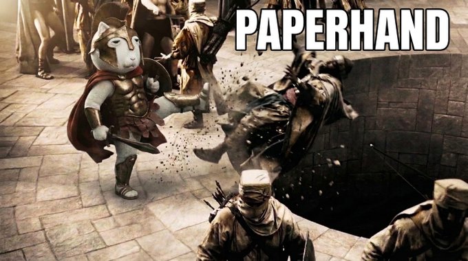 The meme shows a cartoonish white cat character in Roman warrior armor slamming a soldier into a wall, labeled "PAPERHAND," mocking those who sell too early—tying directly to the post's confidence that $KET is about to "reprice" upward. The imagery humorously warns weak-soldiers to hold firm as the token's value rises.