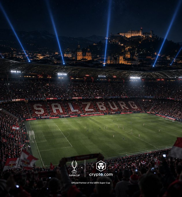The image showcases Red Bull Salzburg's stadium illuminated at night during the UEFA Super Cup, with fans displaying a massive "SALZBURG" banner on the field and the historic Hohensalzburg Fortress visible in the background, alongside Crypto.com branding as the official partner of the event.