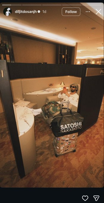 An Instagram story screenshot from "dijfitdosanjh" showing a man lounging in a luxury private airport suite with a suitcase labeled "SATOSHI NAKAMOTO".