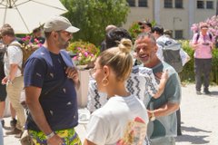 The image shows a group of people standing together, engaged in conversation. The individuals are wearing casual clothing, including t-shirts and hats. One person has their handbag placed next to them. In the background, there is an umbrella and potted plants, adding to the relaxed atmosphere. A post on social media features a photo of these people gathered for a brunch, with text that reads "Punks Brunch Lisbon Punks showed up. They're happy to keep building this with my team at @embassylab". The focus of the image is on the group's interaction and the casual setting they are in.
