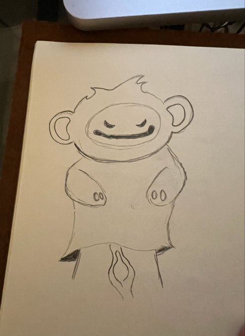 A simple pencil drawing on white paper shows a smiling, monkey-like cartoon figure with rounded ears, closed eyes, small hands, and a tuft of hair on its head.