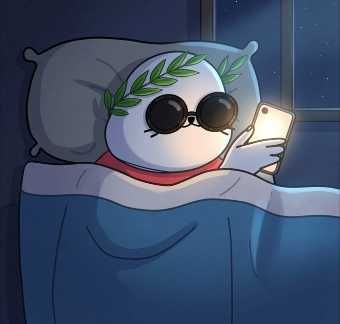 A cute round character wearing round black sunglasses and a green laurel wreath lies in bed under a blue blanket, illuminated by the glow of a smartphone in a dark room with a starry night sky visible through the window. The image captures a relatable late-night doomscrolling moment, matching the "GN" (good night) caption as the character appears to be signing off for the evening.