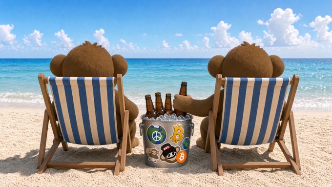 Two plush monkey figures relax on blue-and-white striped beach chairs beside a metal bucket filled with ice and brown bottles, with the bucket decorated with various cryptocurrency stickers (including a peace symbol and a "B" Bitcoin logo). The image visually embodies the post's message—two puppets taking a carefree break from the chaos of crypto markets, with no price charts in sight against the serene ocean backdrop.