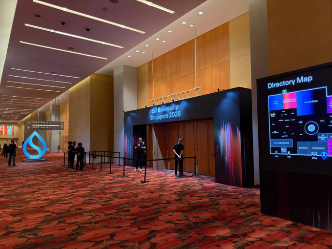 The lobby of the GIL Global Reframing Singapore 2026 conference, showing an empty entrance area with red patterned carpet, signage, staff members, and a large 'Directory Map' display.