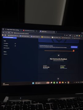 A laptop screen displays the INJ Community Buyback page, with an orange progress bar and an “INJ Buys” program label, reflecting the post’s discussion of quickly filled buyback slots. The accompanying caption says the user missed out, plans to unstake, and will focus more on trading $INJ.