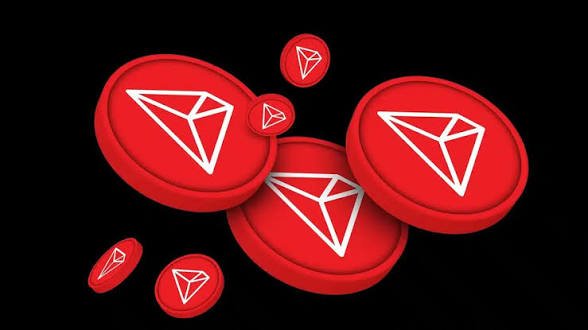 Several red Tron (TRX) cryptocurrency coins with the white diamond logo arranged on a black background.