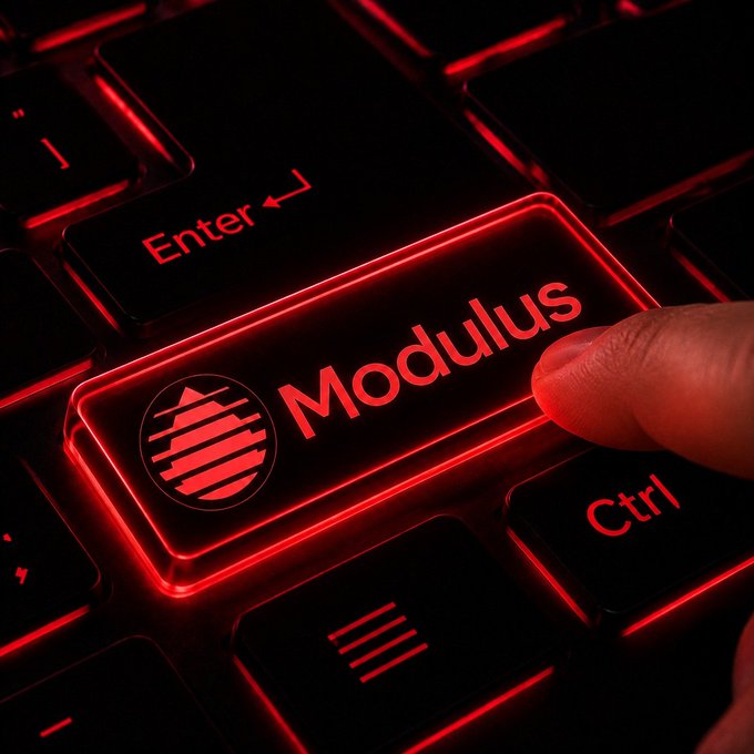 A dramatic close-up of a finger pressing an illuminated red keyboard key labeled 'Modulus' with a circular logo, alongside the 'Enter' and 'Ctrl' keys. The keys are backlit with intense red neon lighting in a dark setting.