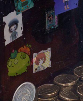 A dark reddish-brown surface displays several small colorful character stickers—including a white-haired figure in a beret, a green cactus-like creature with a pumpkin, and an orange-haired anime-style character—alongside scattered Japanese yen coins (showing values like "500"), visually celebrating Hood Lust's inclusion in Beeple's "JPG CASINO V12" post.