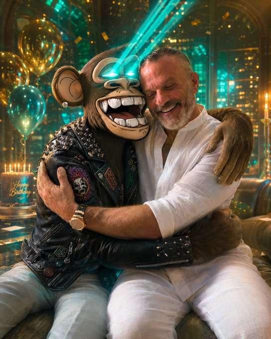 The image features two men sitting next to each other, one wearing a leather jacket and the other wearing white pants. They are both smiling and hugging each other, with balloons floating around them. The background of the photo shows a city skyline at night, creating an urban atmosphere for the scene. The caption of the post reads "Happy birthday @AdamWeitsman the NFT community as a whole is grateful for everything you do! Your @BoredApeYC and all the other NFTs you hold couldn't be in better hands!".