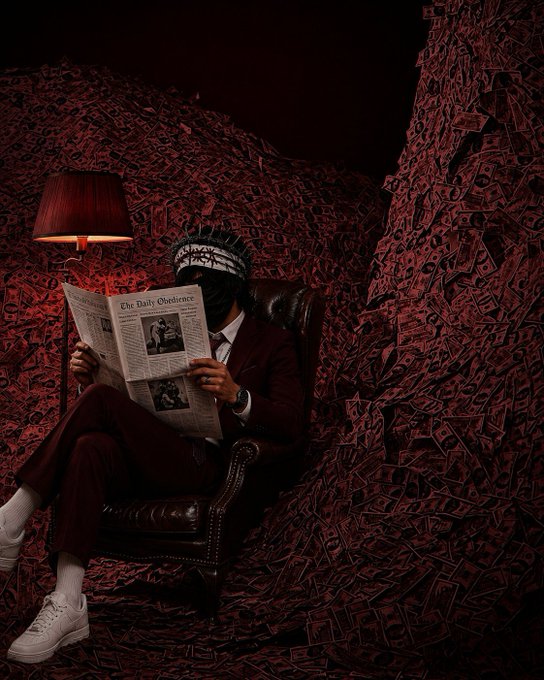 A stylized portrait of a man in a maroon suit reading 'The Daily Observer' newspaper while seated in a leather chair, surrounded by walls covered in red triangular shapes, lit by a red lamp.