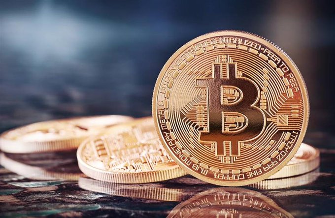 A close-up of gold Bitcoin coins stacked on a reflective dark surface, symbolizing the recent net inflows of $265.7 million into Bitcoin spot ETFs.