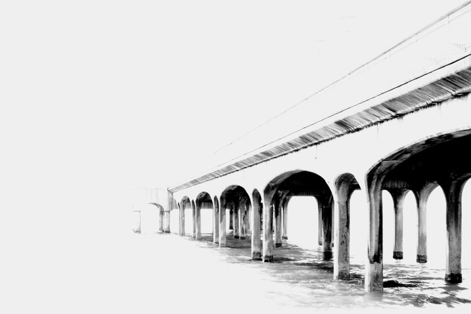 A minimalist black-and-white image of a bridge supported by arches extending into the distance over water.