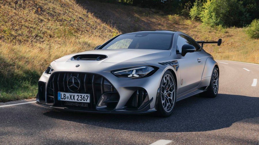 A matte gray Mercedes-AMG sports car parked on an asphalt road with grassy hills in the background; the license plate reads 'LB XX 2367' and the car features an AMG badge.