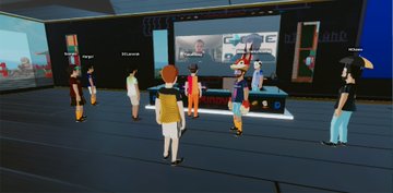 A 3D virtual environment or digital lobby showing several avatar figures gathered in a modern space with display screens and architectural elements.